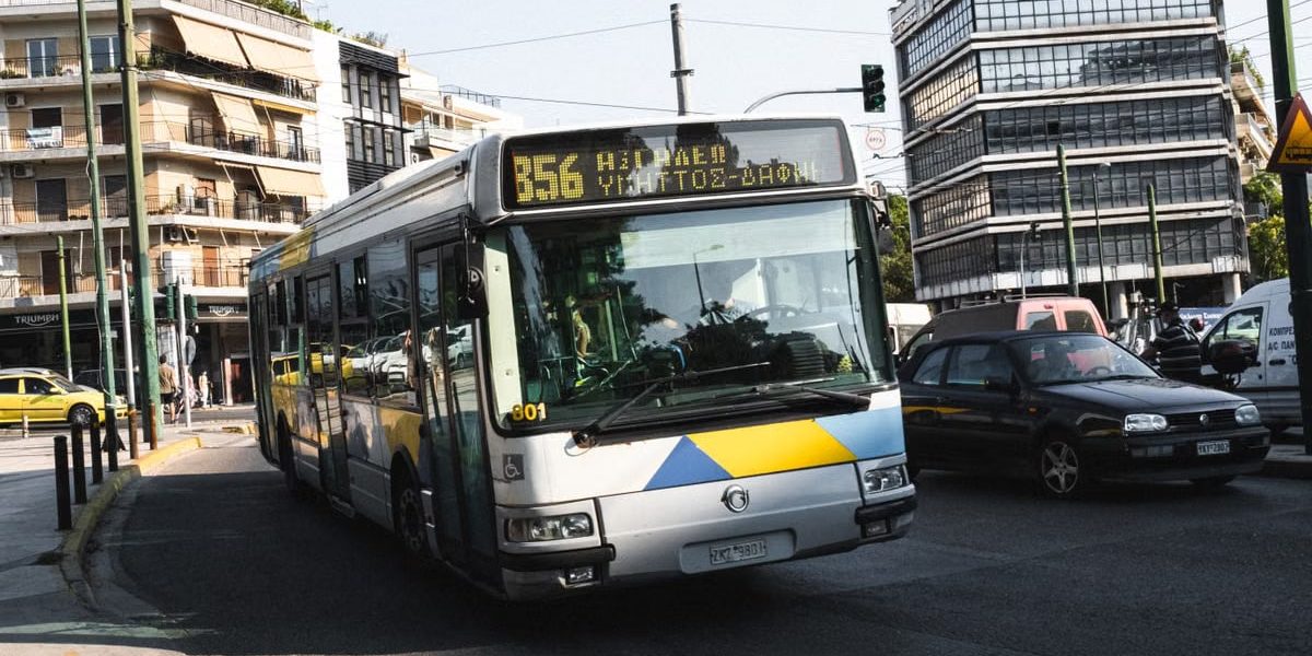 Cityscape of Athens featuring a public bus on a bustling street, capturing urban life.