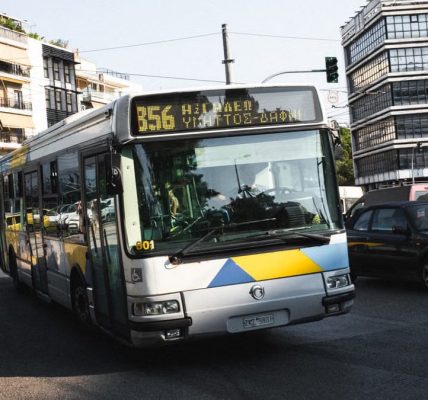 Cityscape of Athens featuring a public bus on a bustling street, capturing urban life.