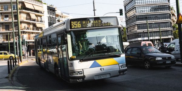 Cityscape of Athens featuring a public bus on a bustling street, capturing urban life.